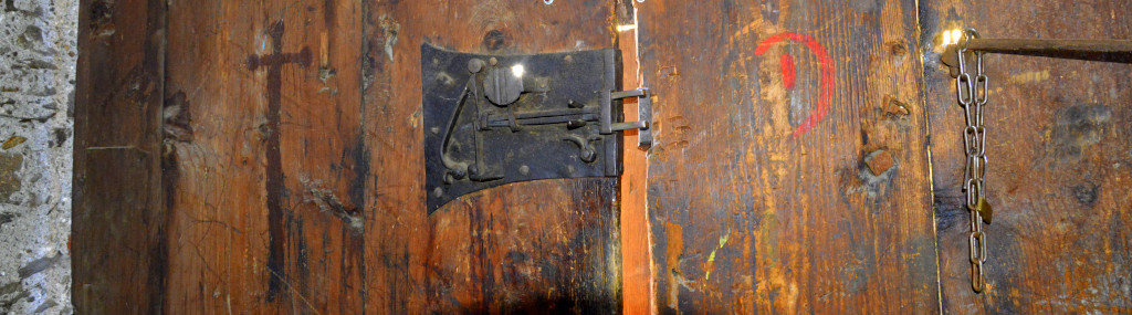 Eine Holztür mit einem schwarzen eisernen Türschloss mit Riegel